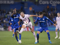 Oriol Romeu of Girona, Allan Romeo Nyom of Getafe, and Yellu Santiago of Getafe fight for the ball during the La Liga 2024/25 match between...