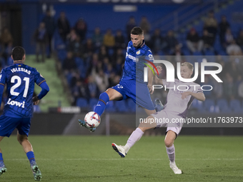 Domingos Duarte of Getafe and Donny van de Beek of Girona fight for the ball during the La Liga 2024/25 match between Getafe and Girona at C...