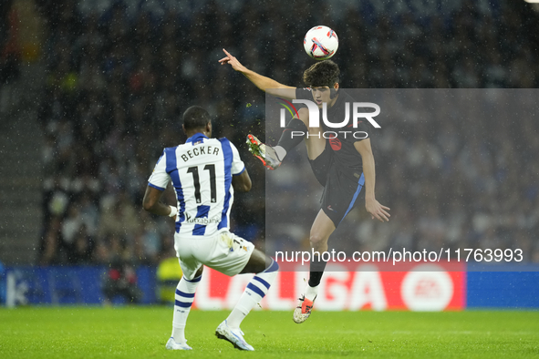 Pau Cubarsi centre-back of Barcelona and Spain and Sheraldo Becker centre-forward of Real Sociedad and Netherlands compete for the ball duri...