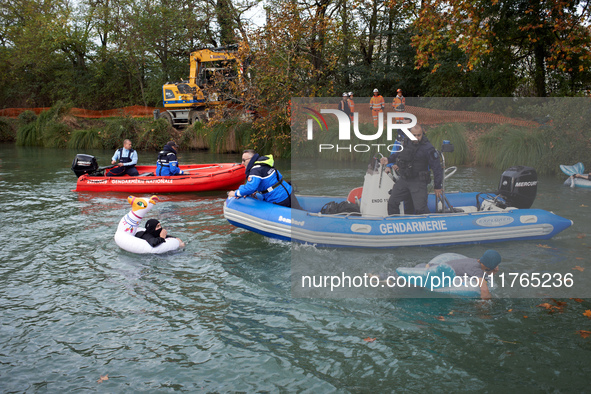 Activists swim in front of river policemen to slow down CNAMO policemen who try to arrest 'ecureuils' living in the trees. The gendarmerie b...