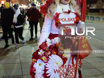 A person dressed in Polish symbols walks the street ahead of the Poland Independence Day in Warsaw, Poland on November 10, 2024. (