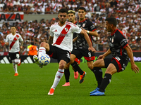 Santiago Simon of River Plate competes for the ball against Maximiliano Puig of Barracas Central during a Liga Profesional 2024 match betwee...