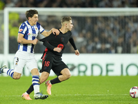 Fermin Lopez central midfield of Barcelona and Spain and Aihen Munoz left-back of Real Sociedad and Spain compete for the ball during the La...