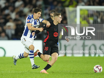 Fermin Lopez central midfield of Barcelona and Spain and Aihen Munoz left-back of Real Sociedad and Spain compete for the ball during the La...