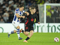 Fermin Lopez central midfield of Barcelona and Spain and Aihen Munoz left-back of Real Sociedad and Spain compete for the ball during the La...