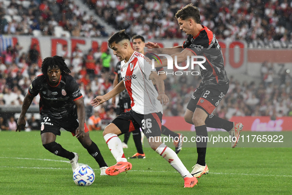 Pablo Solari of River Plate and Carlos Sanchez and Nicolas Carparo of Barracas Central are present during the match between River Plate and...