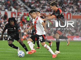 Pablo Solari of River Plate and Carlos Sanchez and Nicolas Carparo of Barracas Central are present during the match between River Plate and...