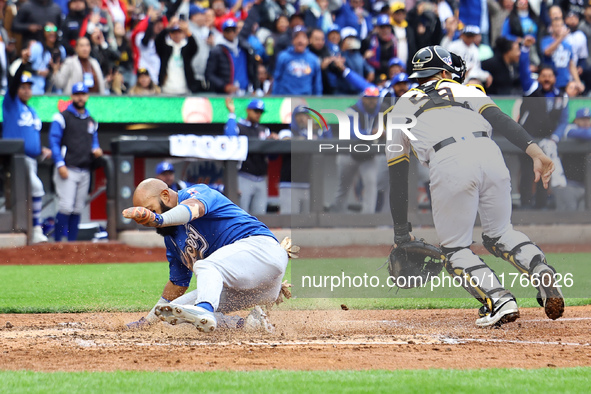 Emilio Bonifacio #64 of Los Tigres del Licey scores during the third inning of a baseball game against Las Aguilas Cibaenas at Citi Field in...