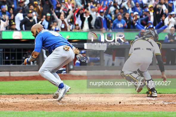 Emilio Bonifacio #64 of Los Tigres del Licey scores during the third inning of a baseball game against Las Aguilas Cibaenas at Citi Field in...