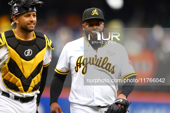 Las Aguilas Cibaenas starting pitcher Johnny Cueto #47 and catcher J.C Escarra #59 come off the field during the second inning of a baseball...