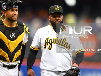 Las Aguilas Cibaenas starting pitcher Johnny Cueto #47 and catcher J.C Escarra #59 come off the field during the second inning of a baseball...