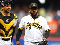 Las Aguilas Cibaenas starting pitcher Johnny Cueto #47 and catcher J.C Escarra #59 come off the field during the second inning of a baseball...