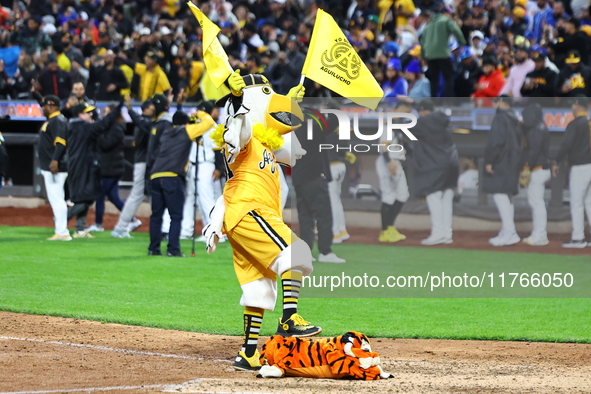 The Las Aguilas Cibaenas mascot celebrates with a stuffed tiger after the team's 3-2 win in the baseball game against Los Tigres del Licey a...