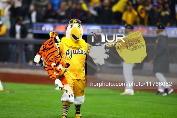 The Las Aguilas Cibaenas mascot celebrates with a stuffed tiger after the team's 3-2 win in the baseball game against Los Tigres del Licey a...