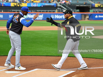 Los Tigres del Licey manager Gilbert Gomez greets Las Aguilas Cibaenas manager Yadier Molina before the baseball game against Las Aguilas Ci...