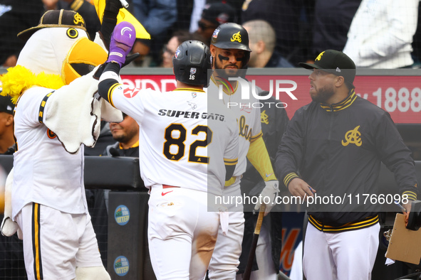 Las Aguilas Cibaenas' Cesar Prieto #82 is congratulated after scoring during the sixth inning of a baseball game against Los Tigres del Lice...