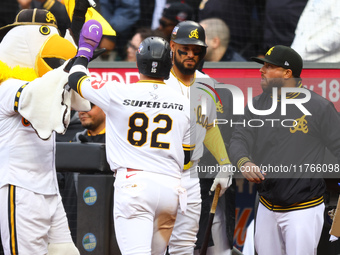 Las Aguilas Cibaenas' Cesar Prieto #82 is congratulated after scoring during the sixth inning of a baseball game against Los Tigres del Lice...