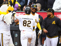 Las Aguilas Cibaenas' Cesar Prieto #82 is congratulated after scoring during the sixth inning of a baseball game against Los Tigres del Lice...