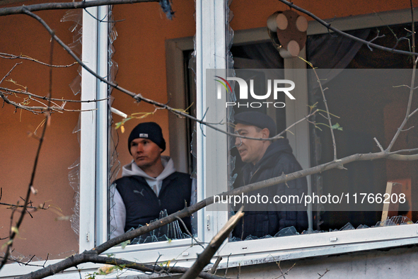 Men stand on the balcony of a residential building damaged by the Russian drone attack in the Khadzhybeiskyi district of Odesa, Ukraine, on...