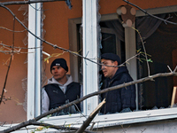 Men stand on the balcony of a residential building damaged by the Russian drone attack in the Khadzhybeiskyi district of Odesa, Ukraine, on...