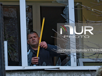 A man stands on the balcony of a residential building damaged by the Russian drone attack in the Khadzhybeiskyi district of Odesa, southern...