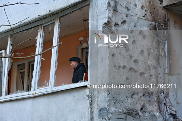 A man stands on the balcony of a residential building damaged by the Russian drone attack in the Khadzhybeiskyi district of Odesa, southern...