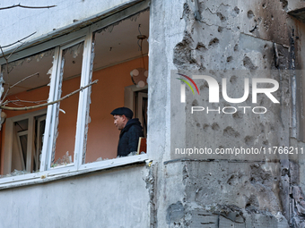 A man stands on the balcony of a residential building damaged by the Russian drone attack in the Khadzhybeiskyi district of Odesa, southern...