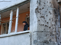 A man stands on the balcony of a residential building damaged by the Russian drone attack in the Khadzhybeiskyi district of Odesa, southern...