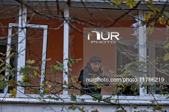 A man stands on the balcony of a residential building damaged by the Russian drone attack in the Khadzhybeiskyi district of Odesa, southern...