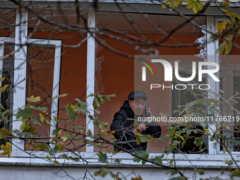 A man stands on the balcony of a residential building damaged by the Russian drone attack in the Khadzhybeiskyi district of Odesa, southern...