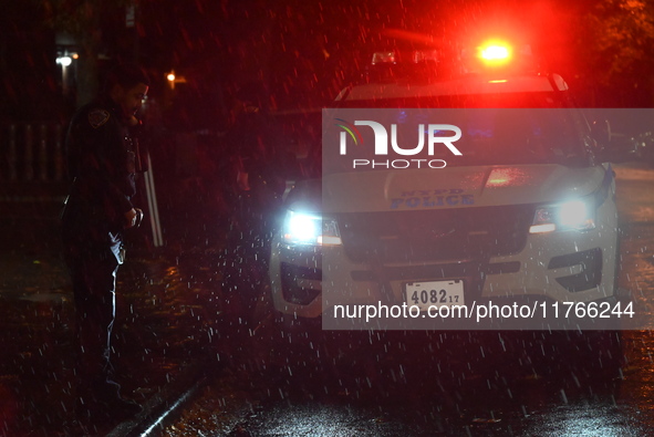 NYPD police officers guard the crime scene as heavy rainfall ends the rainless drought streak. A 16-year-old boy is shot in the East Flatbus...