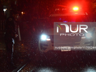 NYPD police officers guard the crime scene as heavy rainfall ends the rainless drought streak. A 16-year-old boy is shot in the East Flatbus...