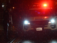 NYPD police officers guard the crime scene as heavy rainfall ends the rainless drought streak. A 16-year-old boy is shot in the East Flatbus...