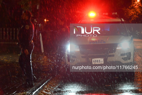 NYPD police officers guard the crime scene as heavy rainfall ends the rainless drought streak. A 16-year-old boy is shot in the East Flatbus...