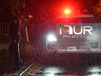 NYPD police officers guard the crime scene as heavy rainfall ends the rainless drought streak. A 16-year-old boy is shot in the East Flatbus...