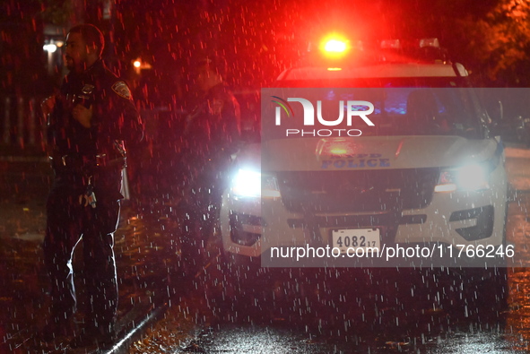 NYPD police officers guard the crime scene as heavy rainfall ends the rainless drought streak. A 16-year-old boy is shot in the East Flatbus...