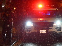 NYPD police officers guard the crime scene as heavy rainfall ends the rainless drought streak. A 16-year-old boy is shot in the East Flatbus...