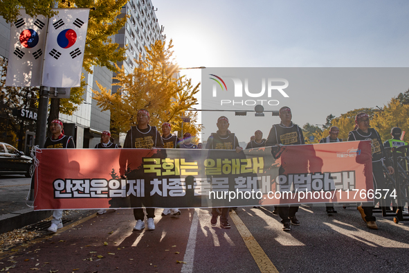 Members of the Cargo Truckers Solidarity Division of the Korean Public Service and Transport Workers' Union under the KCTU march near the Na...