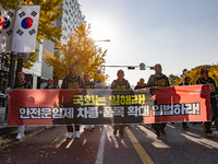 Members of the Cargo Truckers Solidarity Division of the Korean Public Service and Transport Workers' Union under the KCTU march near the Na...