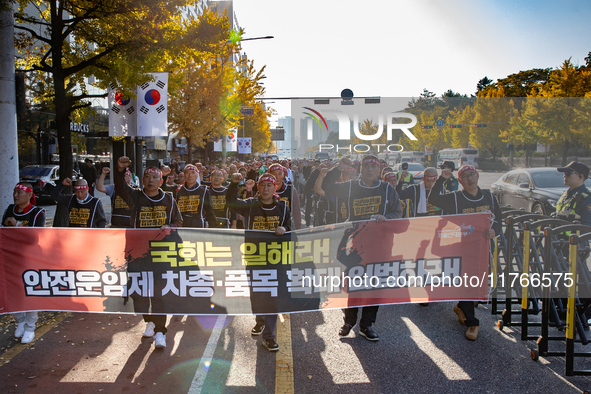 Members of the Cargo Truckers Solidarity Division of the Korean Public Service and Transport Workers' Union under the KCTU march near the Na...