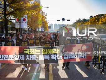 Members of the Cargo Truckers Solidarity Division of the Korean Public Service and Transport Workers' Union under the KCTU march near the Na...