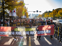 Members of the Cargo Truckers Solidarity Division of the Korean Public Service and Transport Workers' Union under the KCTU march near the Na...