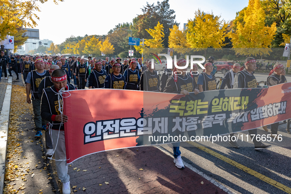 Members of the Cargo Truckers Solidarity Division of the Korean Public Service and Transport Workers' Union under the KCTU march near the Na...