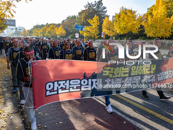 Members of the Cargo Truckers Solidarity Division of the Korean Public Service and Transport Workers' Union under the KCTU march near the Na...