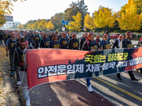 Members of the Cargo Truckers Solidarity Division of the Korean Public Service and Transport Workers' Union under the KCTU march near the Na...