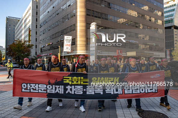 Members of the Cargo Truckers Solidarity Division of the Korean Public Service and Transport Workers' Union under the KCTU march near the Na...