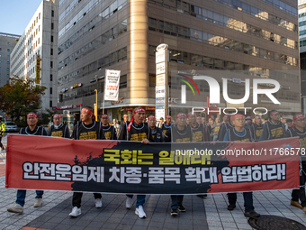 Members of the Cargo Truckers Solidarity Division of the Korean Public Service and Transport Workers' Union under the KCTU march near the Na...