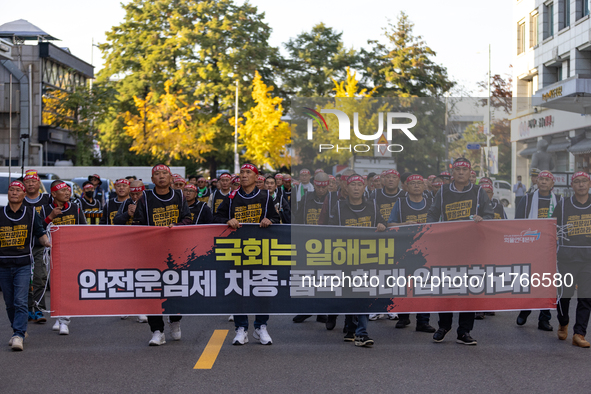 Members of the Cargo Truckers Solidarity Division of the Korean Public Service and Transport Workers' Union under the KCTU march near the Na...