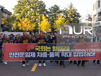 Members of the Cargo Truckers Solidarity Division of the Korean Public Service and Transport Workers' Union under the KCTU march near the Na...