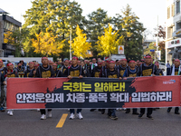 Members of the Cargo Truckers Solidarity Division of the Korean Public Service and Transport Workers' Union under the KCTU march near the Na...